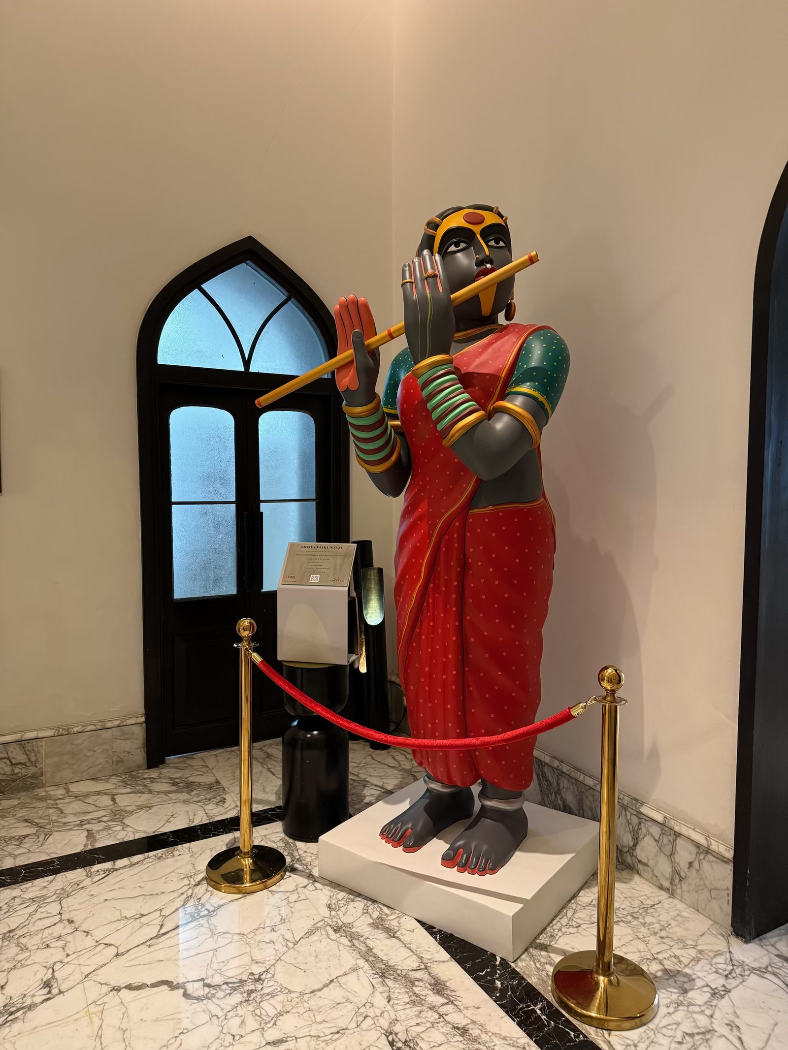 Thota Vaikuntam’s standing figure of a Telangana woman playing the flute, in a red sari with green bangles, cordoned by a red rope at Welcomhotel by ITC Hotels, Amritsar